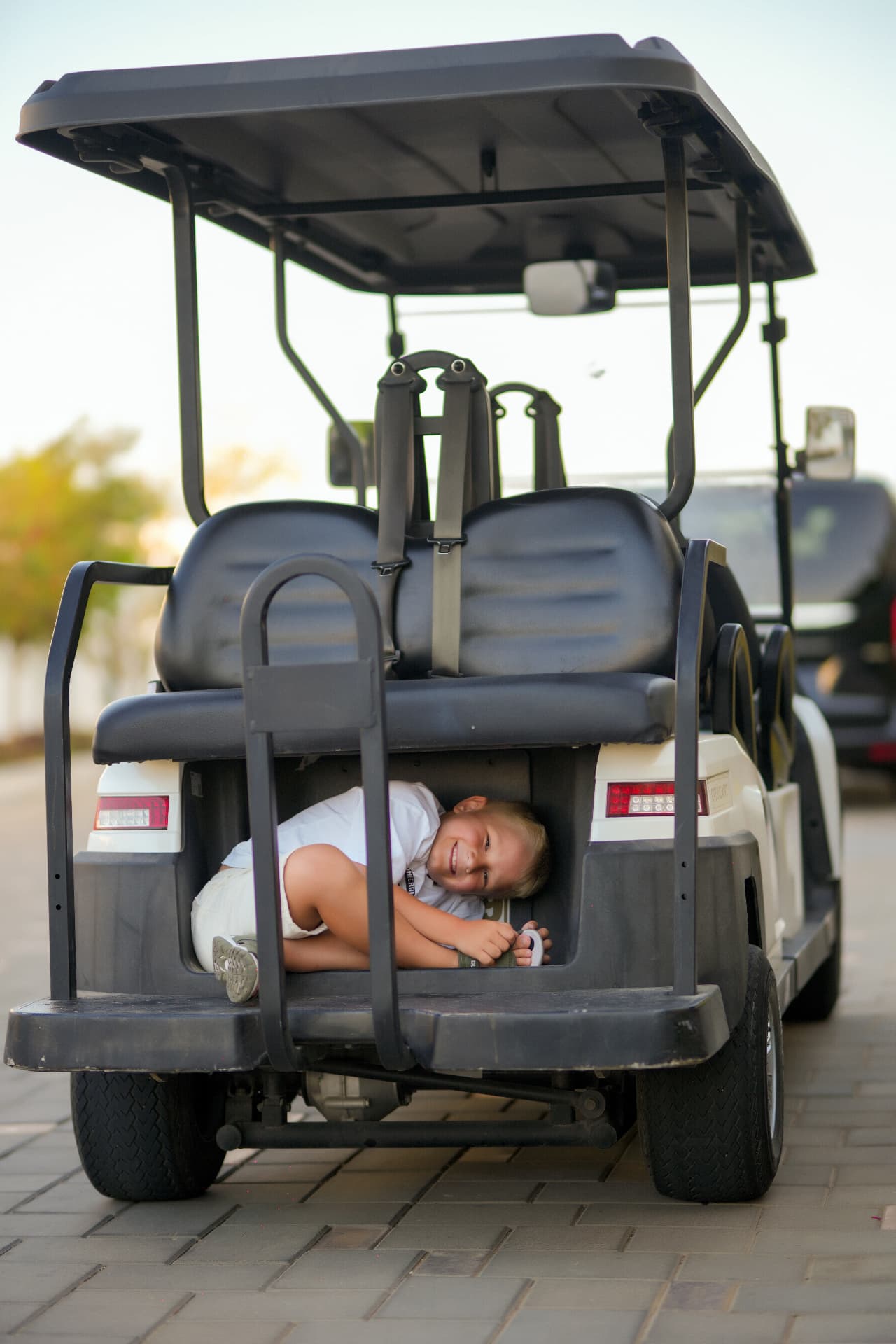 Boy laughing while lying in the back of a golf cart
