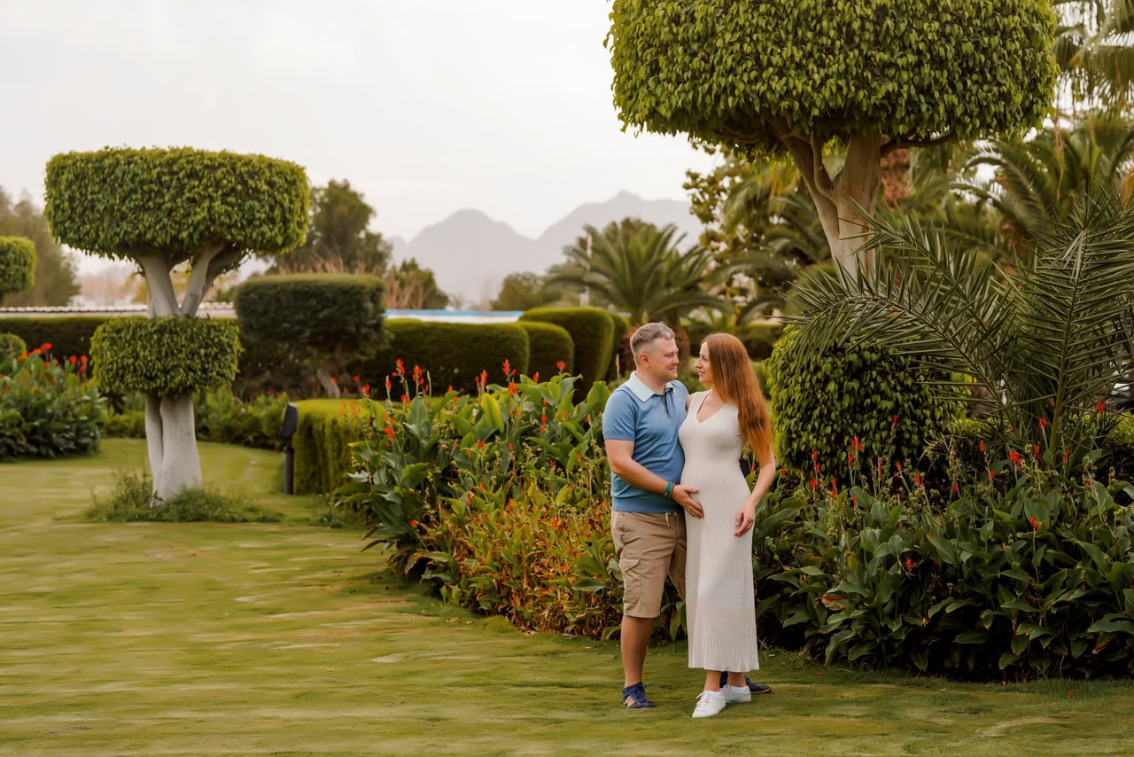 Couple standing on a manicured lawn with mountains in the distance