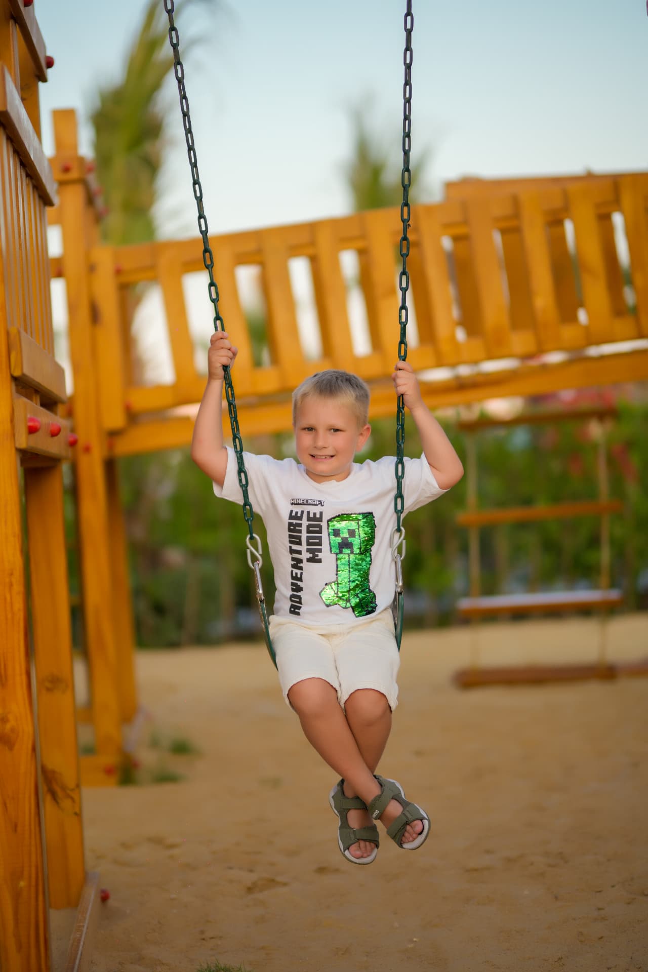 Boy on a playground swing at golden hour