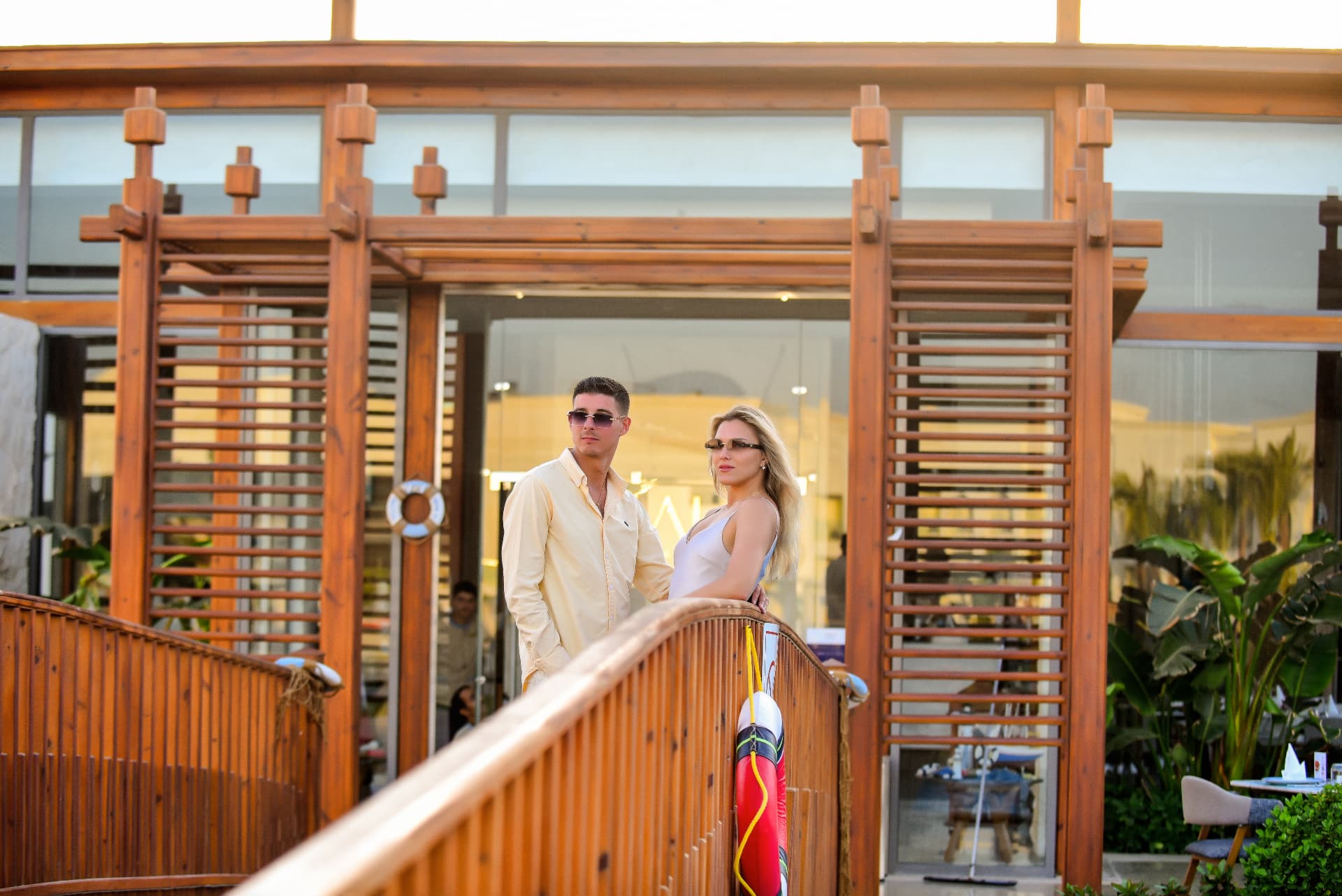 Couple standing on a wooden bridge at a beach restaurant